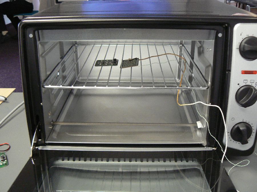 Die bestückte Platine wird in einen handelsüblichen Tischgrill gelegt. 1400 Watt sollte der Ofen schon haben, damit die erforderliche Temperatur über einige Minuten konstant gehalten werden kann.